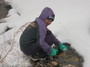 Asha collecting a water sample.